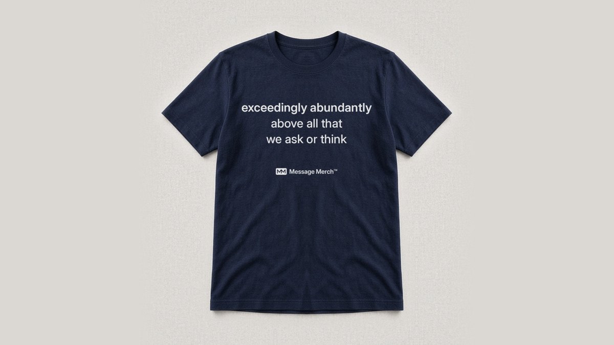 Navy shirt printed with exceedingly abundantly above all that we ask or think, with a small Message Merch logo under the words